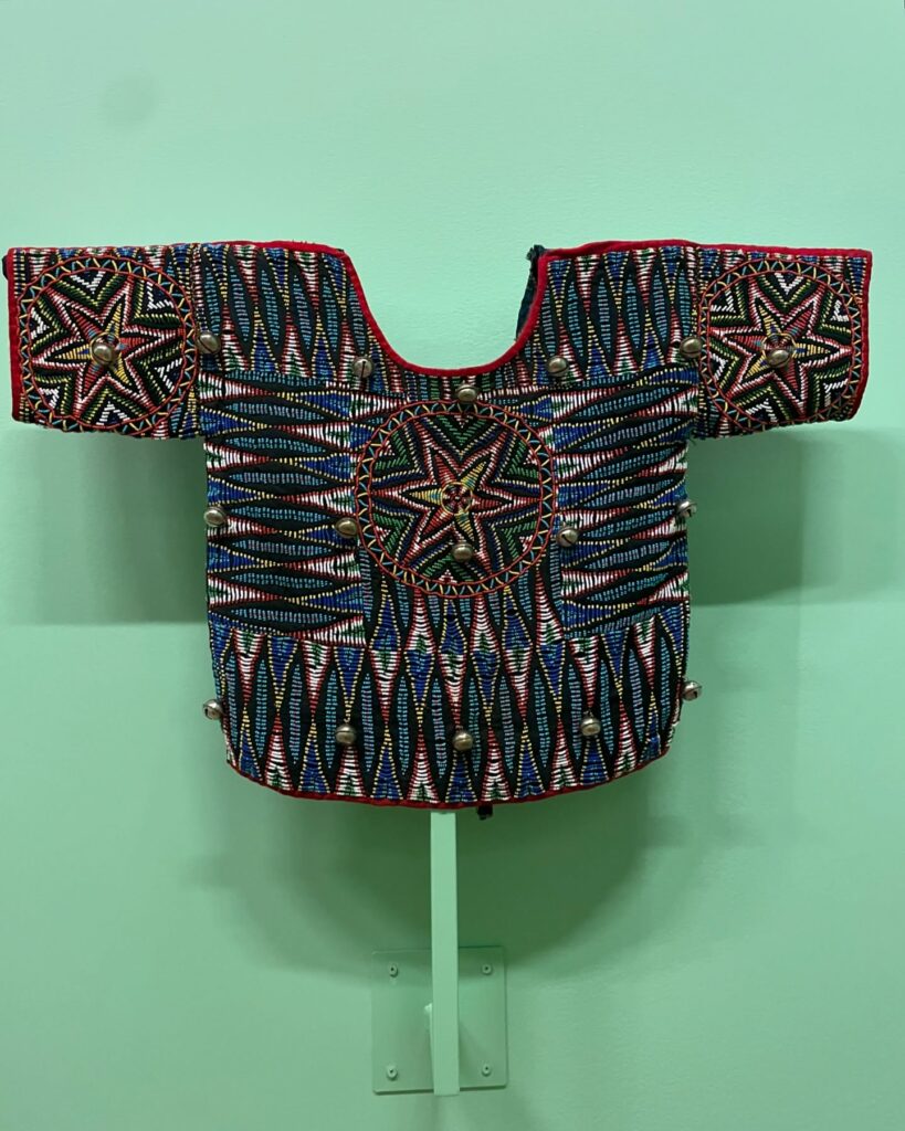 Foto tirada da exposição de moda africana em São Paulo mostrando blusa com estampas geométricas.