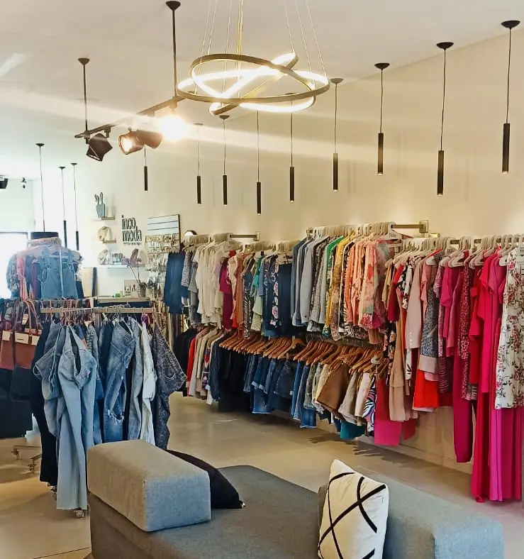 Foto do brechó onde fui realizar o trabalho de personal shopping. A foto mostra arras de roupas diversas.