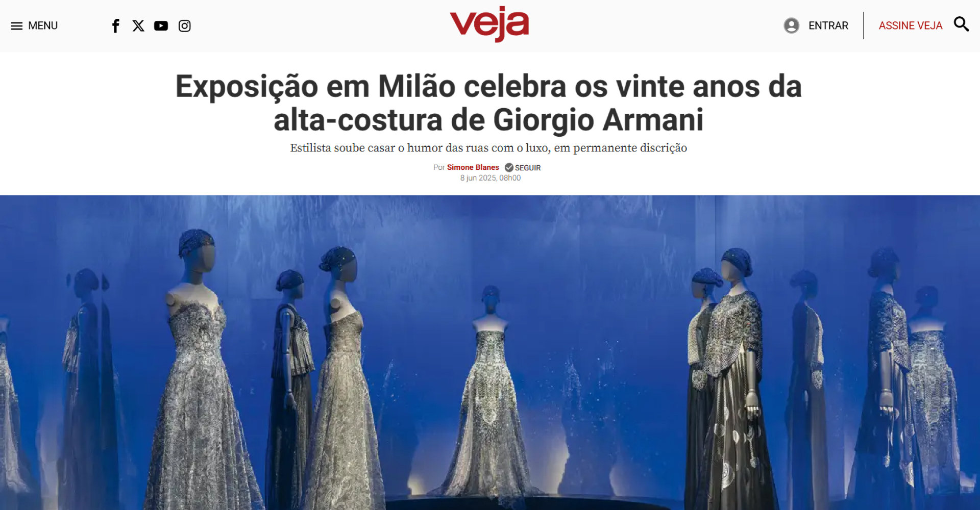 Print da matéria da Veja. Na imagem, lê-se "Exposição em Milão celebra os vinte anos da alta-costura de Giorgio Armani". Há também uma foto de sua exposição com manequins usando vestidos longos na cor prata.