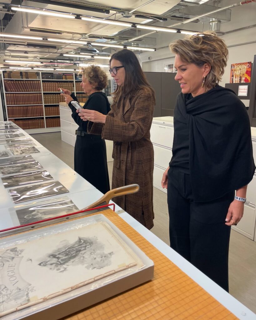 Foto da Silvia Scigliano e Marcia Crivorot vendo imagens da primeira revista Vogue.