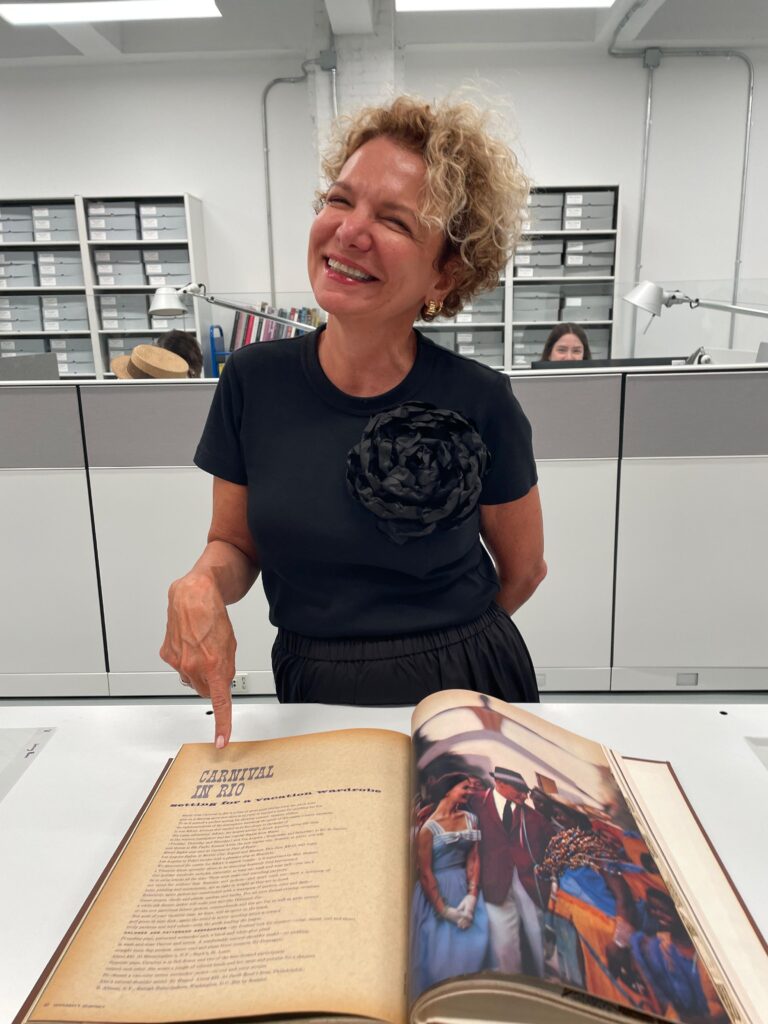 Na foto, Marcia Crivorot, aparece apontando o dedo para uma matéria do Carnaval no Rio em revista vougue antiga na exposição da Condé Nast