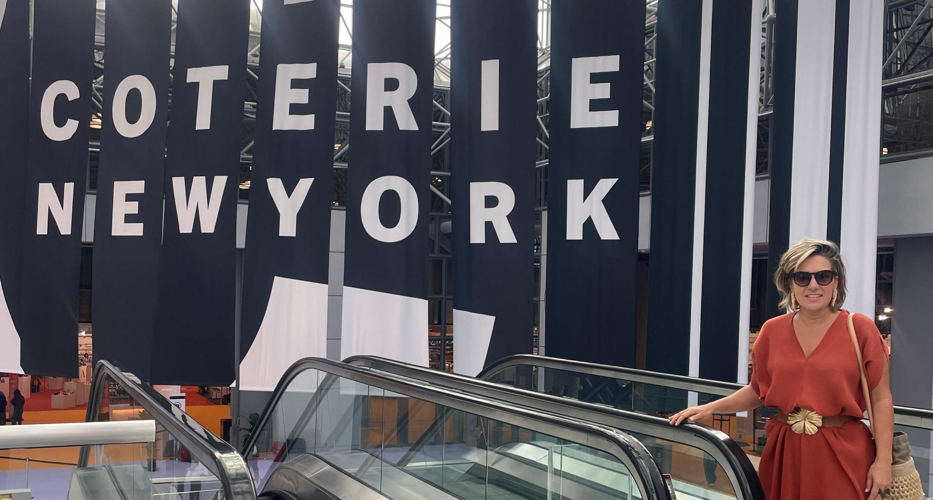 Foto da Silvia em frente o painel de entrada da Coterie New York