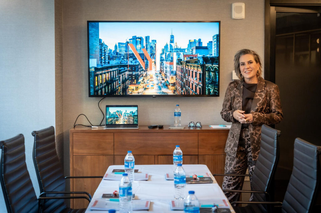 Na foto mostra a Silvia Scigliano ao lado de um monitor durante a promeira aula do NY Fashion Tour, edição de fevereiro de 2026, em Nova York.