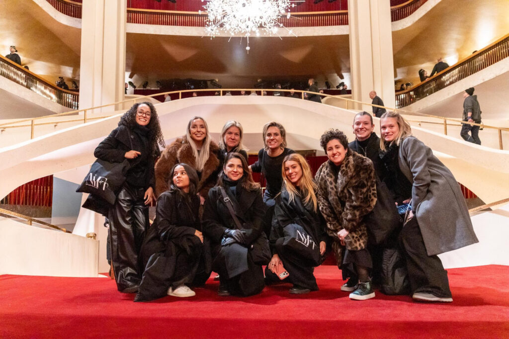 Grupo de alunas do New York Fashion Tour na passarela do desfile da Michael Kors Collection.