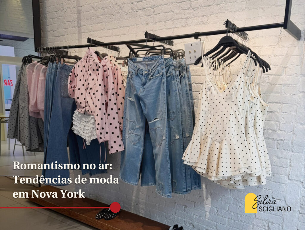 Foto mostra arara de loja com calças jenas, blusas estilo corsets com bolinhas e camisa também com estampa de poá. Em cima da foto há escrito: "Romantismo no ar: Tendências de moda em Nova York"