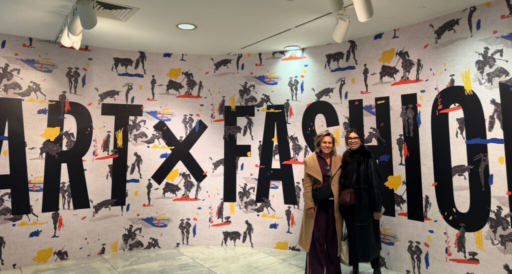 Foto da Silvia Scigliano na entrada da exposição Art x Fashion que aborda sobre o tema "moda é arte?"